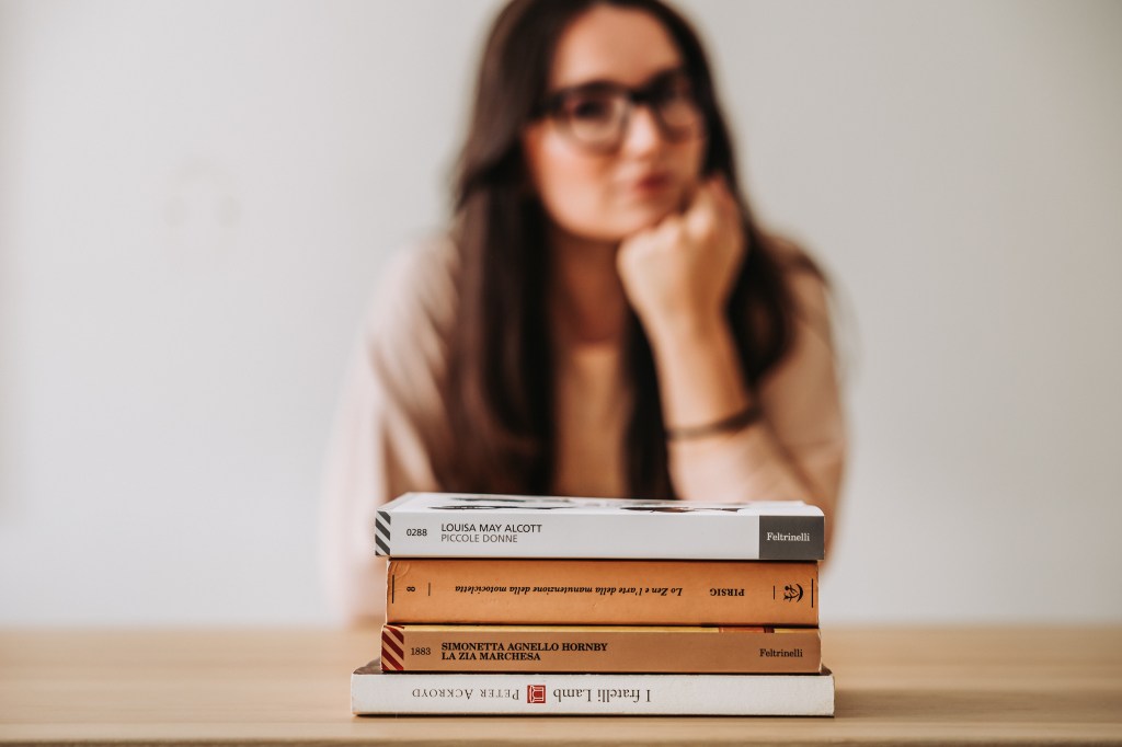 Daria di The Lazy factory dietro a una pila di libri